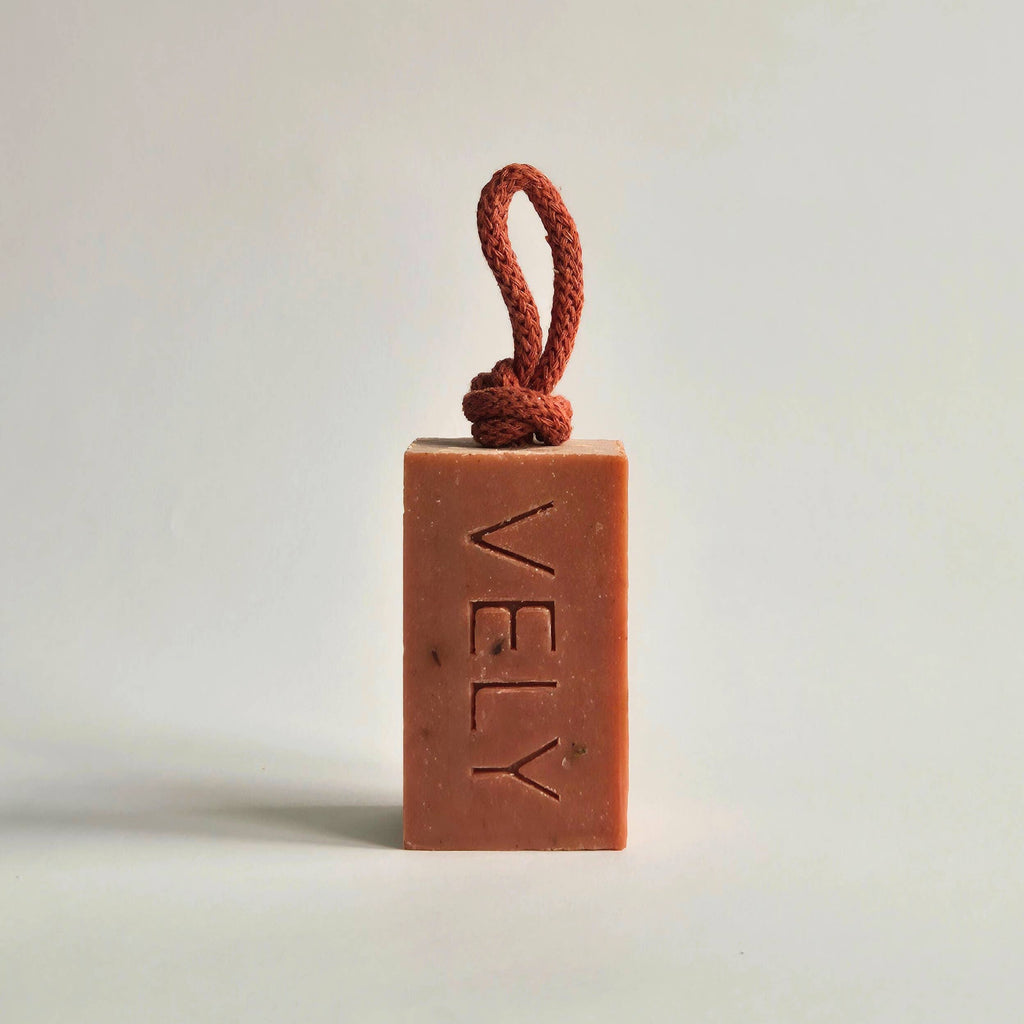 Boudoir french red clay soap bar on a rope on light grey background