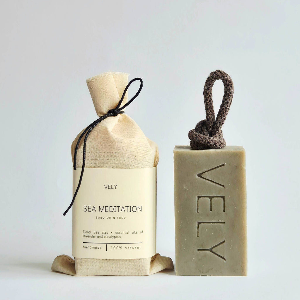 Sea meditation VELY soap bar next to cotton pouch on a light grey background
