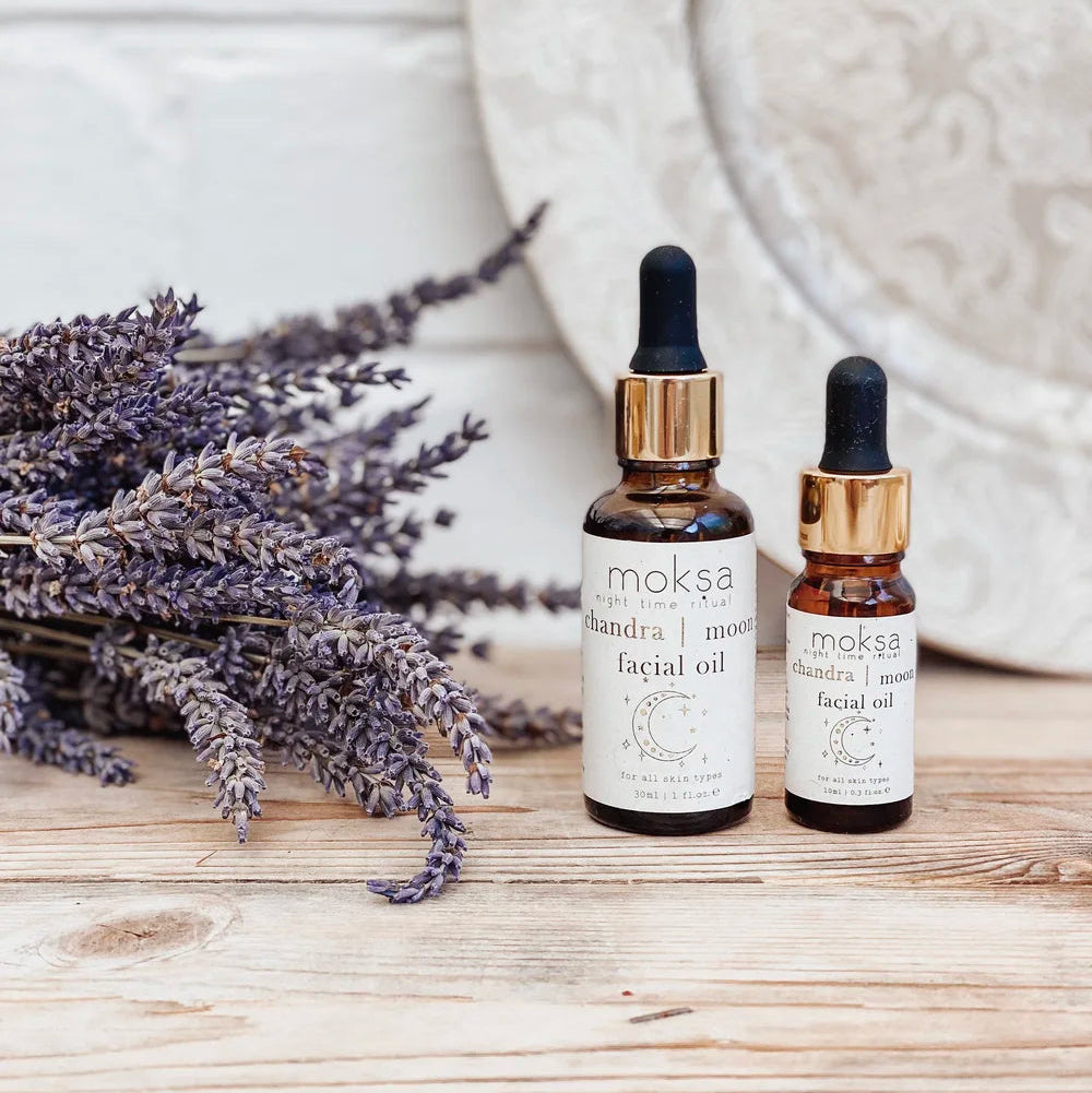 Two bottles of Moksa Chandra facial oil with lavender on a wooden surface.