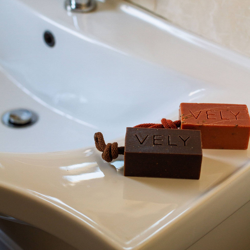 Two bars of soap labeled 'VELY' on a bathroom sink.