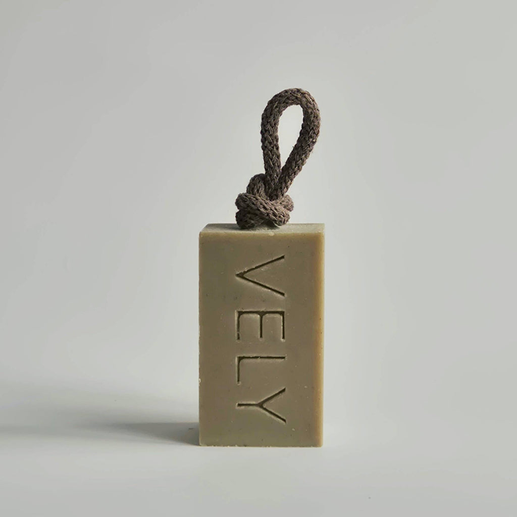 Bar of soap with a rope on a light gray background