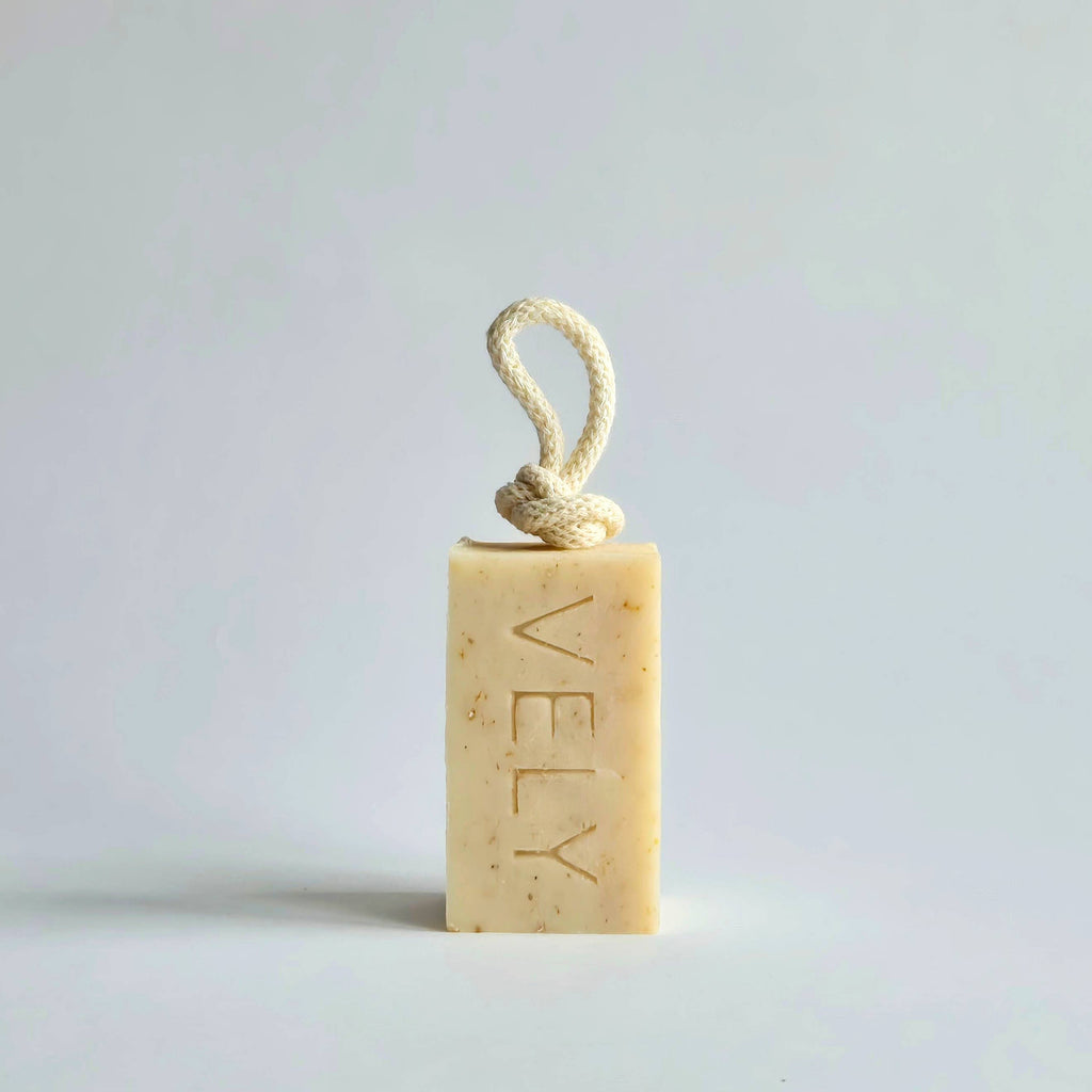 Rectangular soap bar with a rope handle on a light gray background